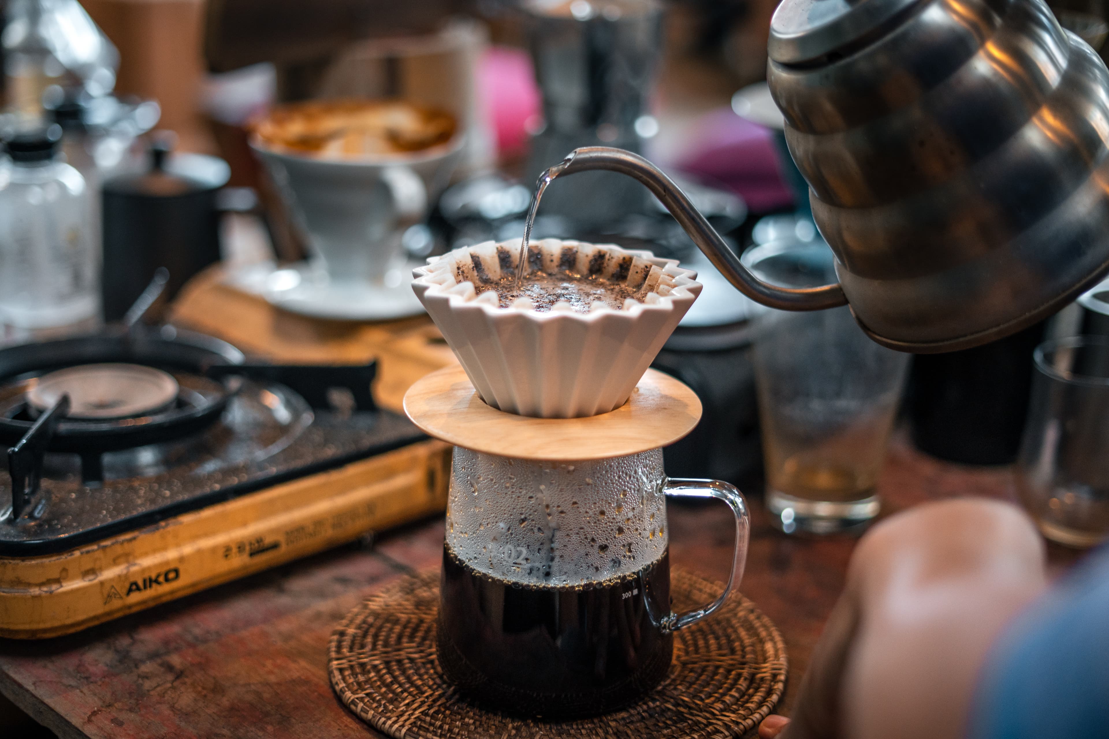 Coffee brewing setup with a kettle, carafe, and freshly ground beans